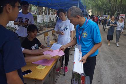 工作人员向校友赠送纪念品和介绍活动流程
